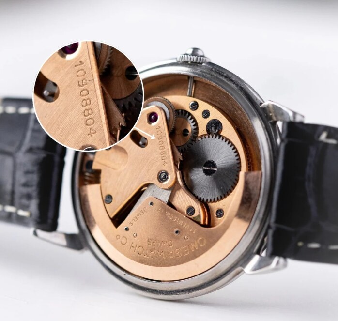 Macro shot of the Omega calibre 561 movement with serial number engraved on the bridge, jewels and gilt finishing