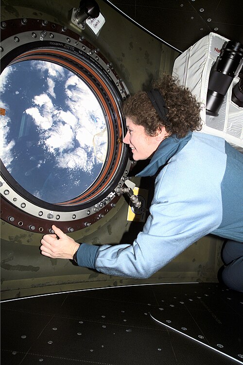 Susan Helms à bord de l'ISS, regardant par le hublot, photo NASA