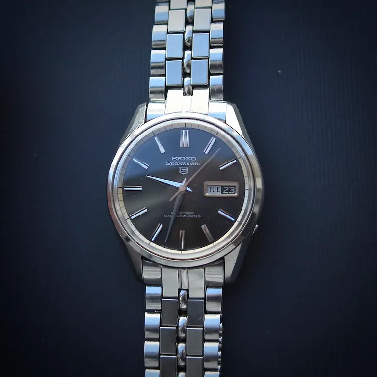 Seiko Sportsmatic 5 referentie 6619-8060 uit 1963, zwarte gezonnebrilde wijzerplaat en originele stalen band